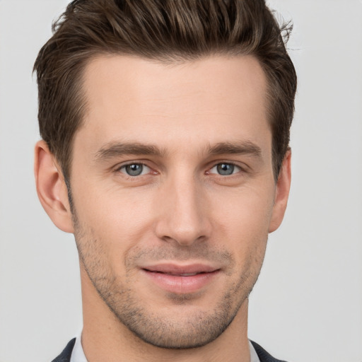 Joyful white young-adult male with short  brown hair and grey eyes