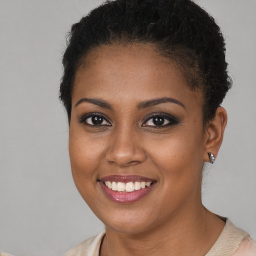 Joyful black young-adult female with short  brown hair and brown eyes