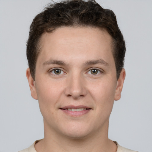 Joyful white young-adult male with short  brown hair and grey eyes