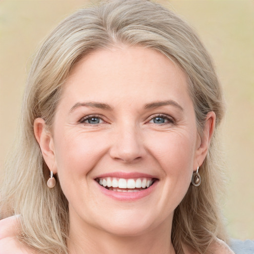 Joyful white young-adult female with medium  brown hair and blue eyes