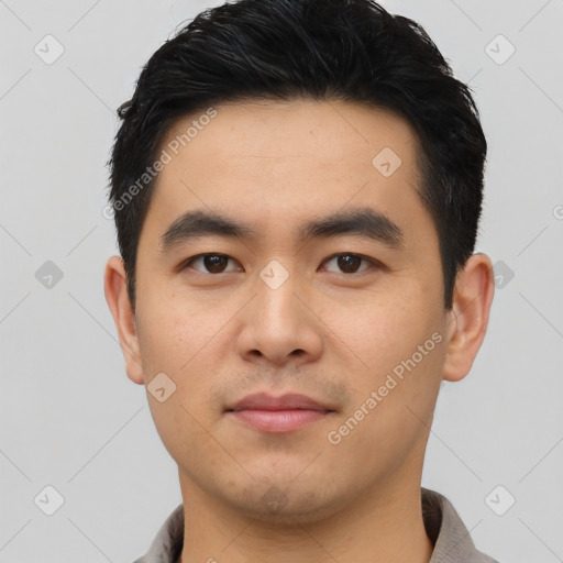 Joyful asian young-adult male with short  black hair and brown eyes