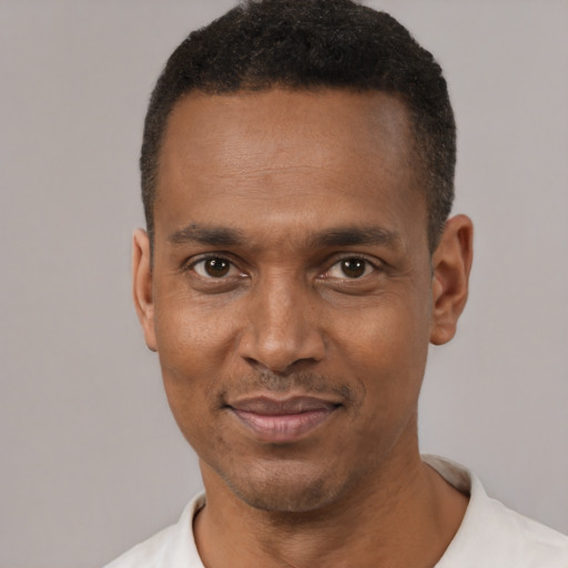 Joyful black young-adult male with short  black hair and brown eyes