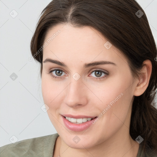 Joyful white young-adult female with medium  brown hair and grey eyes