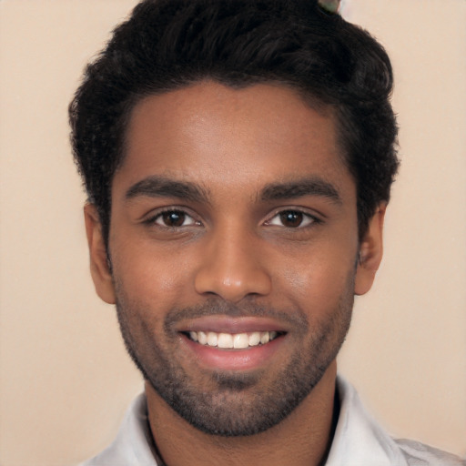 Joyful black young-adult male with short  black hair and brown eyes