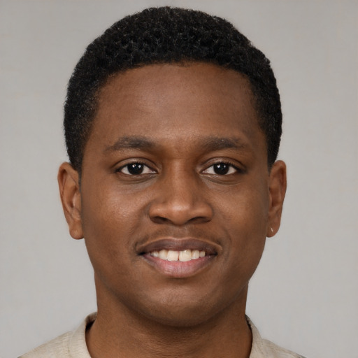 Joyful black young-adult male with short  brown hair and brown eyes