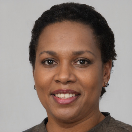 Joyful black adult female with short  black hair and brown eyes