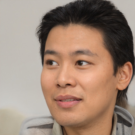 Joyful black young-adult male with short  brown hair and brown eyes