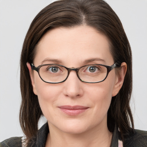 Joyful white young-adult female with medium  brown hair and grey eyes