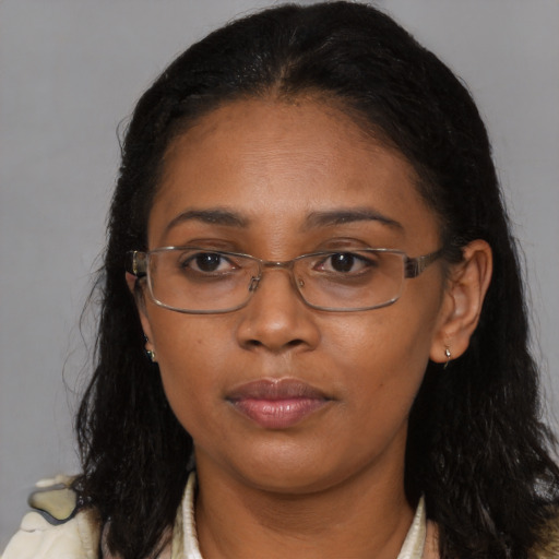 Joyful black young-adult female with long  brown hair and brown eyes