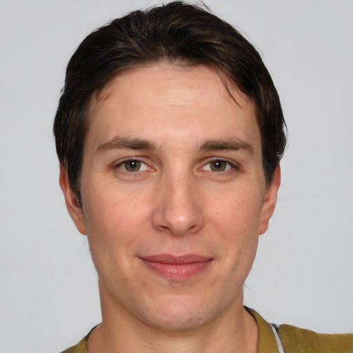 Joyful white young-adult male with short  brown hair and grey eyes