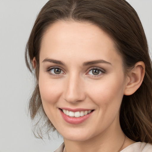 Joyful white young-adult female with medium  brown hair and grey eyes