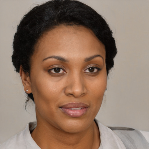 Joyful black young-adult female with short  brown hair and brown eyes