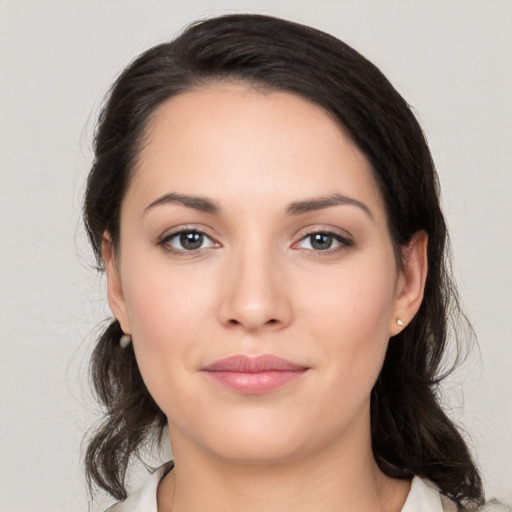 Joyful white young-adult female with medium  black hair and brown eyes