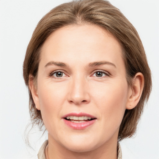 Joyful white young-adult female with medium  brown hair and grey eyes