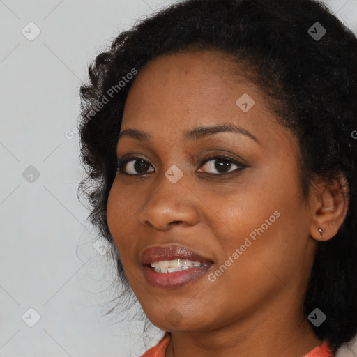 Joyful black young-adult female with long  black hair and brown eyes