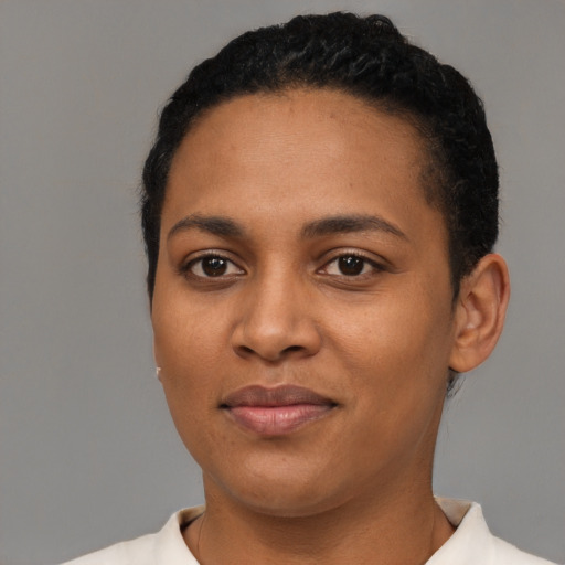 Joyful black young-adult female with short  black hair and brown eyes