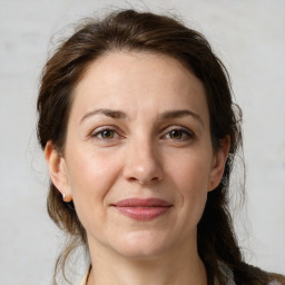 Joyful white adult female with medium  brown hair and grey eyes