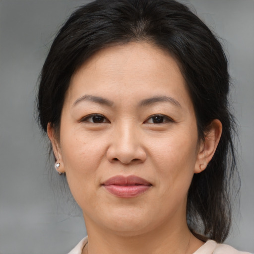 Joyful asian adult female with medium  brown hair and brown eyes