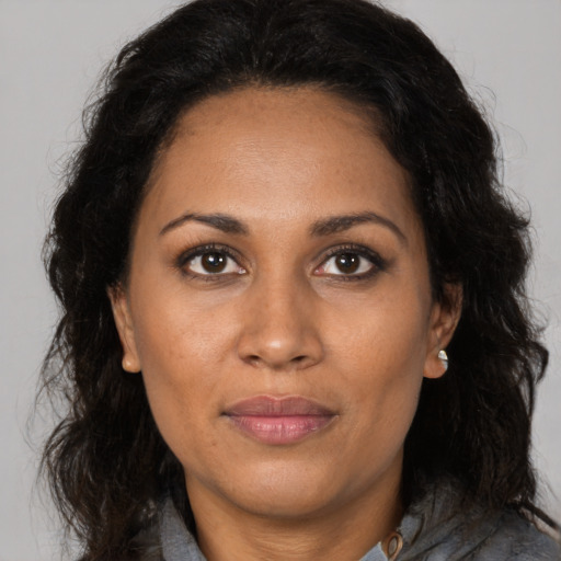 Joyful black adult female with long  brown hair and brown eyes