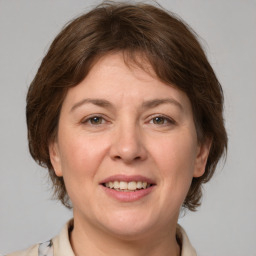 Joyful white adult female with medium  brown hair and grey eyes