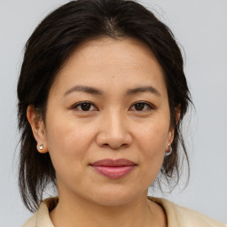 Joyful asian adult female with medium  brown hair and brown eyes