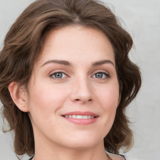 Joyful white young-adult female with medium  brown hair and blue eyes