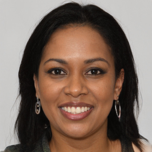 Joyful black young-adult female with long  black hair and brown eyes