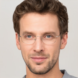 Joyful white young-adult male with short  brown hair and grey eyes