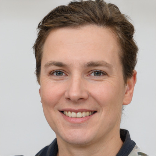 Joyful white young-adult female with short  brown hair and grey eyes