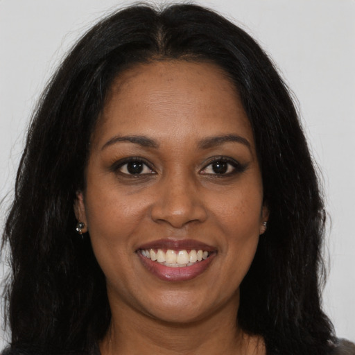 Joyful black young-adult female with long  brown hair and brown eyes