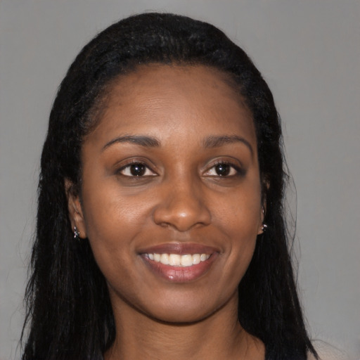 Joyful black young-adult female with long  black hair and brown eyes