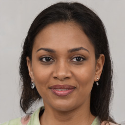 Joyful black young-adult female with medium  brown hair and brown eyes