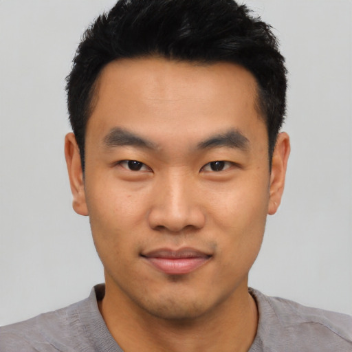 Joyful asian young-adult male with short  black hair and brown eyes