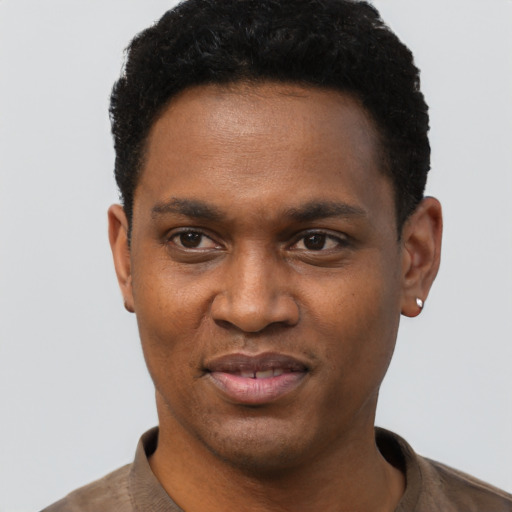 Joyful black young-adult male with short  black hair and brown eyes