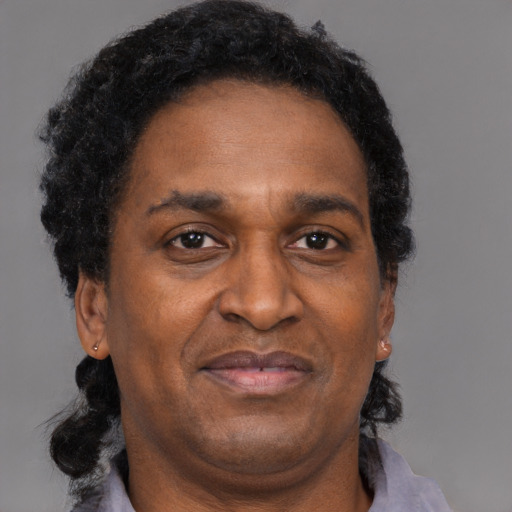 Joyful black adult male with short  brown hair and brown eyes