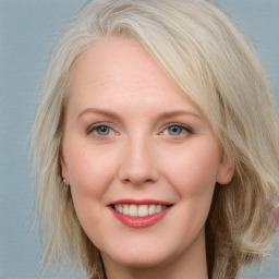 Joyful white adult female with medium  brown hair and blue eyes