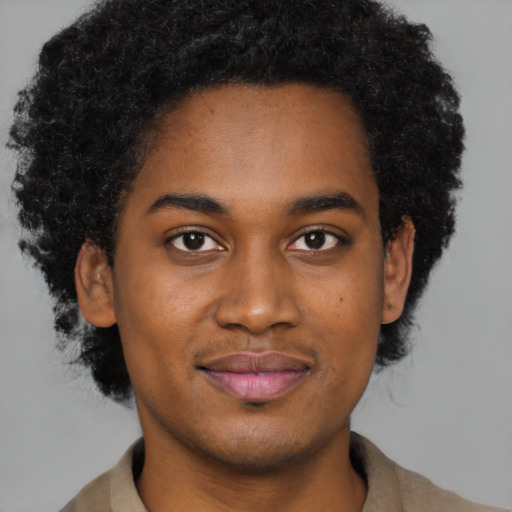 Joyful black young-adult male with short  brown hair and brown eyes