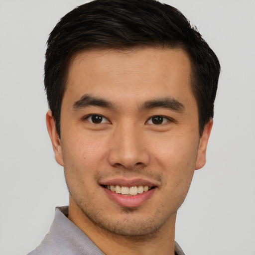 Joyful asian young-adult male with short  brown hair and brown eyes