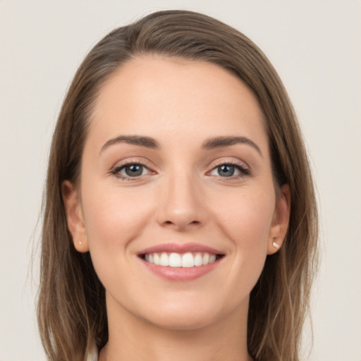 Joyful white young-adult female with long  brown hair and grey eyes