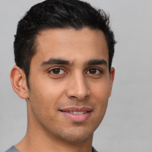 Joyful latino young-adult male with short  brown hair and brown eyes