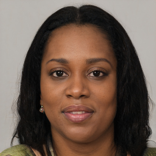 Joyful black young-adult female with long  black hair and brown eyes