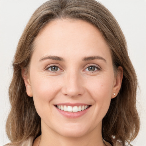 Joyful white young-adult female with medium  brown hair and grey eyes