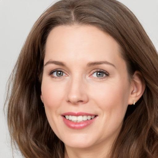 Joyful white young-adult female with long  brown hair and grey eyes