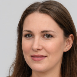 Joyful white adult female with long  brown hair and brown eyes