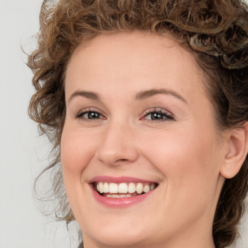 Joyful white young-adult female with medium  brown hair and green eyes