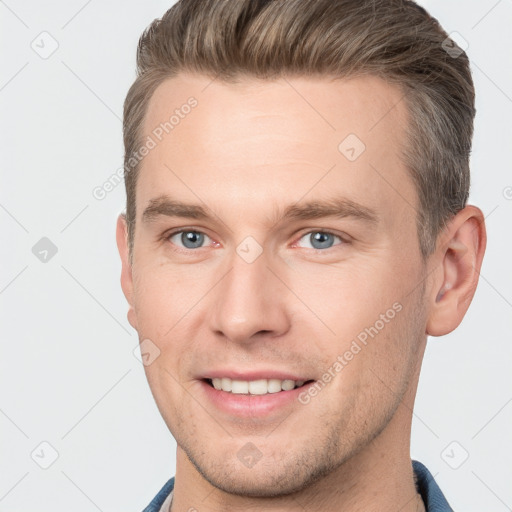 Joyful white young-adult male with short  brown hair and grey eyes