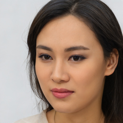 Joyful asian young-adult female with long  brown hair and brown eyes