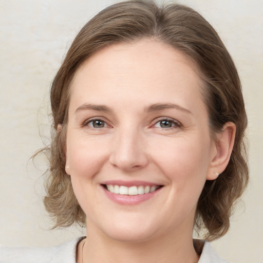 Joyful white young-adult female with medium  brown hair and green eyes