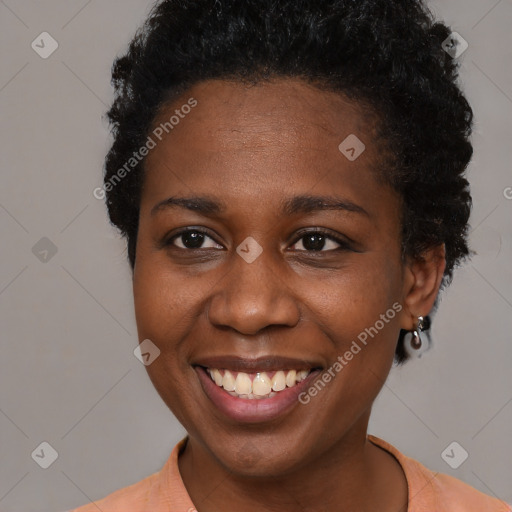 Joyful black young-adult female with short  black hair and brown eyes