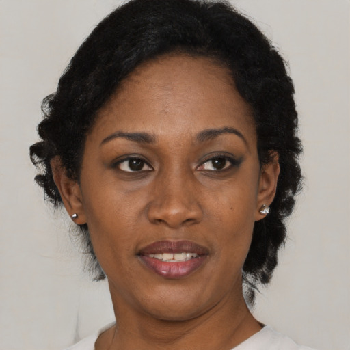Joyful black adult female with medium  black hair and brown eyes